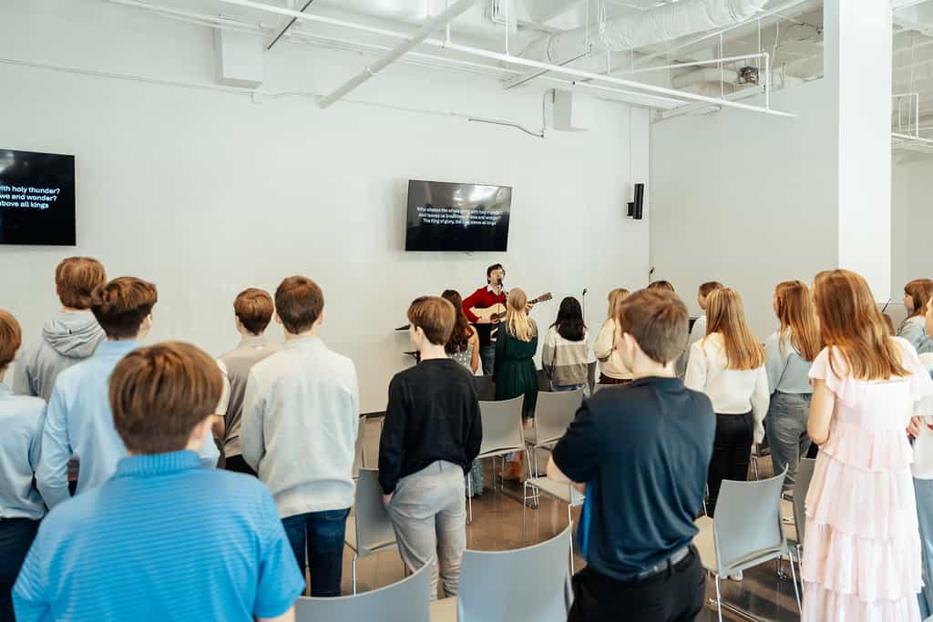 Junior high students standing and singing during worship - PCPC's Sunday School Classes for Middle School in Dallas.