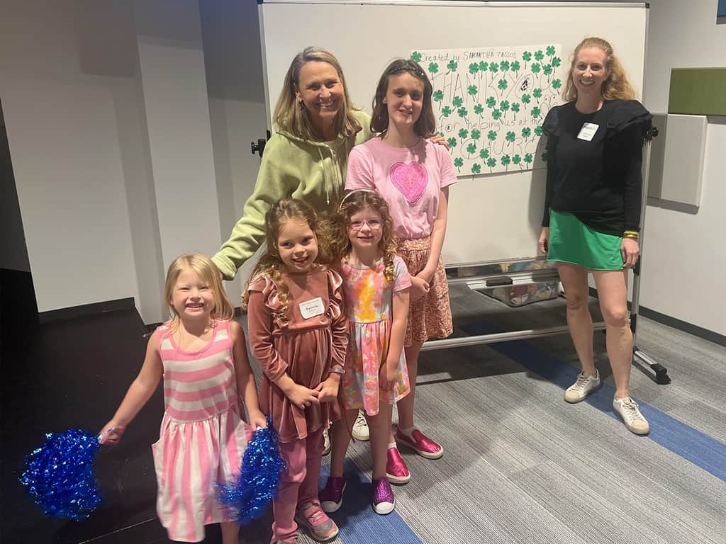 Volunteers and children smiling in front of a thank-you poster at a Dallas church with a special needs program.