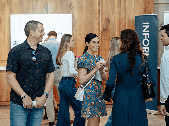 Church members talking and connecting near an information table in the church lobby.