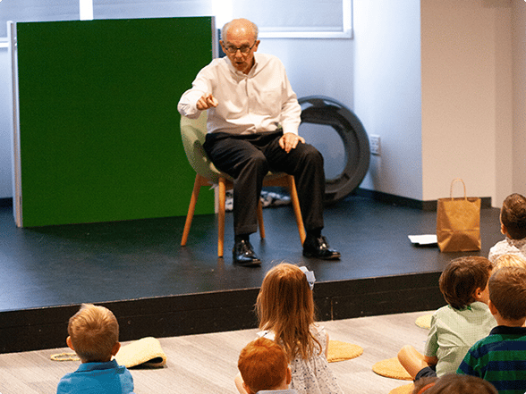 Older man teaching Bible lesson to children in preschool kids ministry setting..
