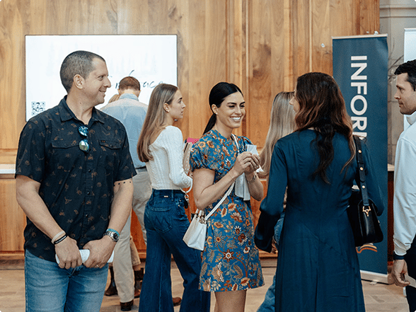 Church members talking and connecting near an information table in the church lobby.