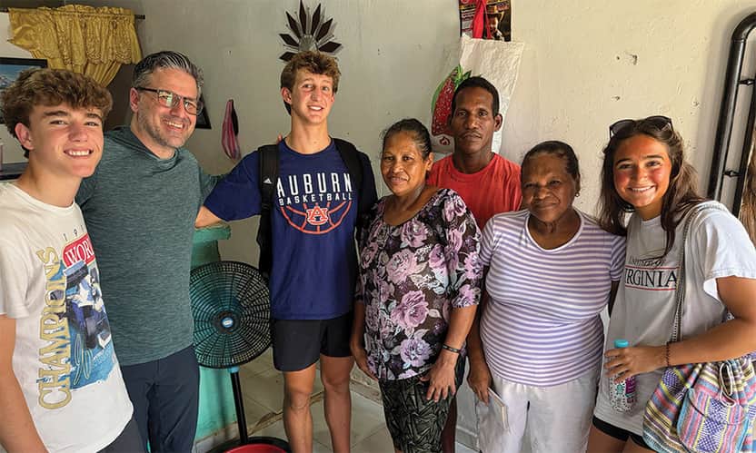 Church mission team visiting local family during outreach trip.