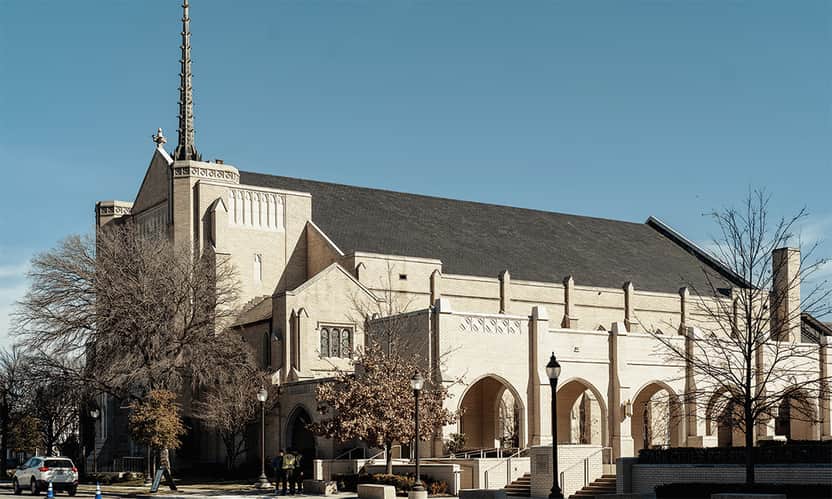 Exterior view of the Park Cities Presbyterian Church sanctuary building with tall steeple and arched entrances.