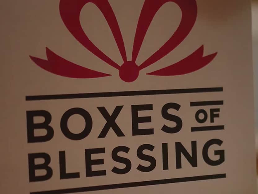 Boxes of Blessing ministry sign with red gift logo.